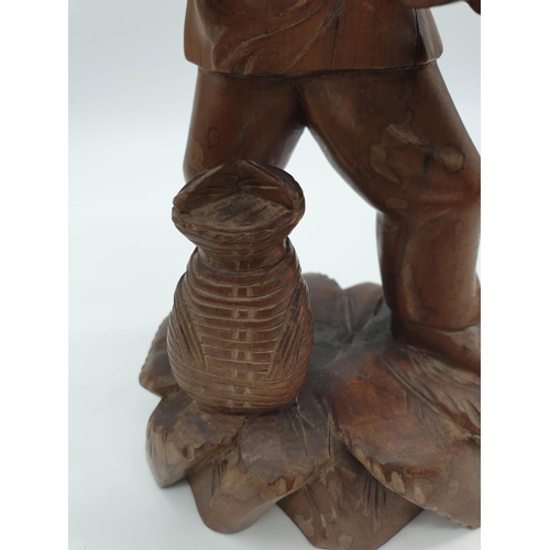 247 - A Chinese wooden hand Carved Fisherman holding a large fish, 22cm tall