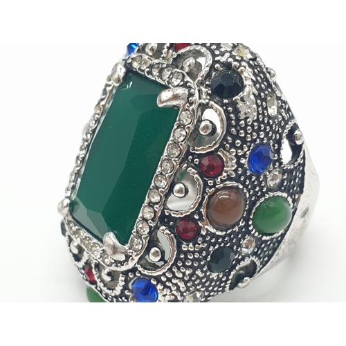 308 - A multi coloured silver ring with jade centre stone. 22.7g in weight. Size L.