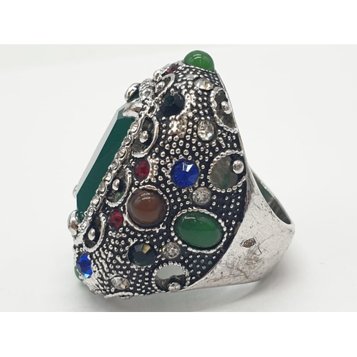 308 - A multi coloured silver ring with jade centre stone. 22.7g in weight. Size L.