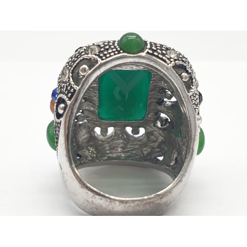 308 - A multi coloured silver ring with jade centre stone. 22.7g in weight. Size L.