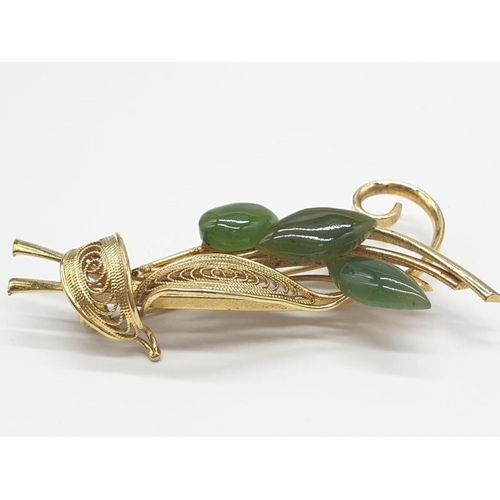 447 - A yellow metal and jade filigree brooch. 10g in weight. 5cm in length.