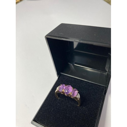 182 - 9ct gold and amethyst ring. Having three faceted and amethysts to top and diamond points to shoulder... 