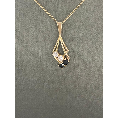 640 - Pendant with chain; both in 9K yellow gold. Pendant with CZ and sapphires. Chain is aprox 15