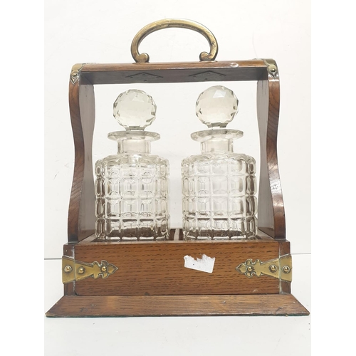 366 - An Edwardian decanter tantalus cabinet; including two decanter bottles. Comes with key.