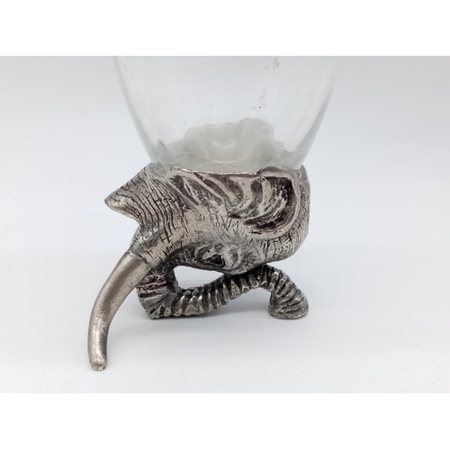 355 - A hunter's drinking cup with white metal base, in the style of an elephant. 17cm in height.