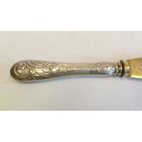 143 - A silver gilt-in scripted large fish knife; with decorated handle. 27cm long.