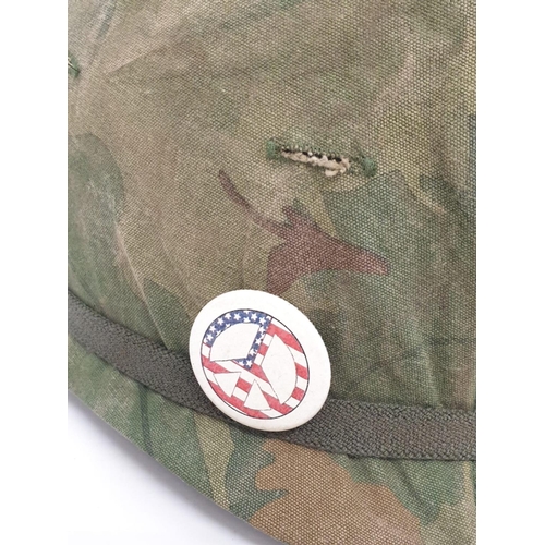 76 - Vietnam War Era US M1 Helmet with Reversible Mitch-Duck Hunter Cover. The peace pin may be post war.