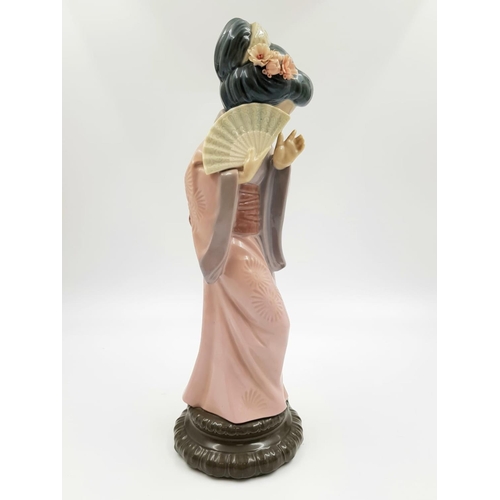 192 - A Lladro porcelain figurine of a timid Japanese Geisha with fan. Very good condition. 30cm high.