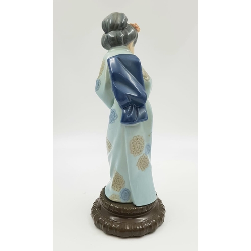 629 - A Lladro Japanese porcelain figurine in a 'Sayonara' pose. 27cm high. Good condition.