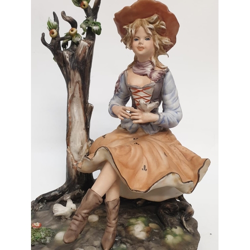 976 - A Capodimonte figure of a pretty girl playing with birds.