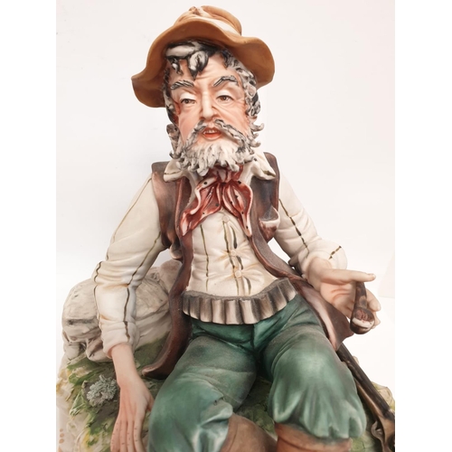 978 - A Capodimonte figure of a resting hunter. 25cm tall, 26cm diameter.