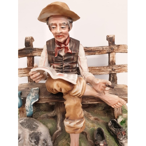 980 - A Capodimonte figure of an old man drying his socks.  22cm height x 28cm diameter.