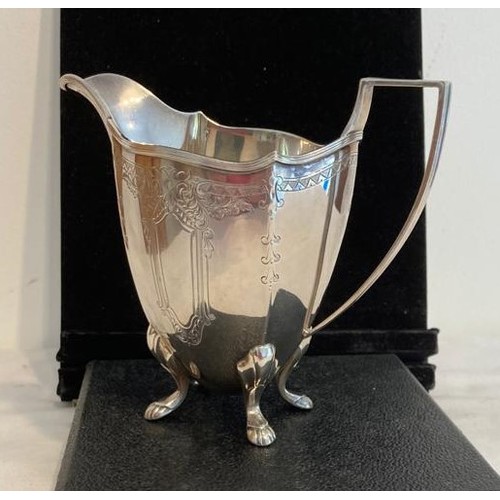 974 - Solid silver upright milk jug, having four cabriole legs with paw feet.  Attractive chased design to... 