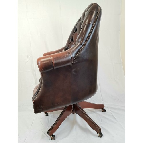 41 - A vintage Chesterfield directors swivel office chair. Brown leather, deep buttoned and flanked by sc... 