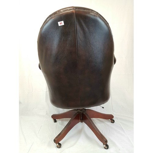 41 - A vintage Chesterfield directors swivel office chair. Brown leather, deep buttoned and flanked by sc... 