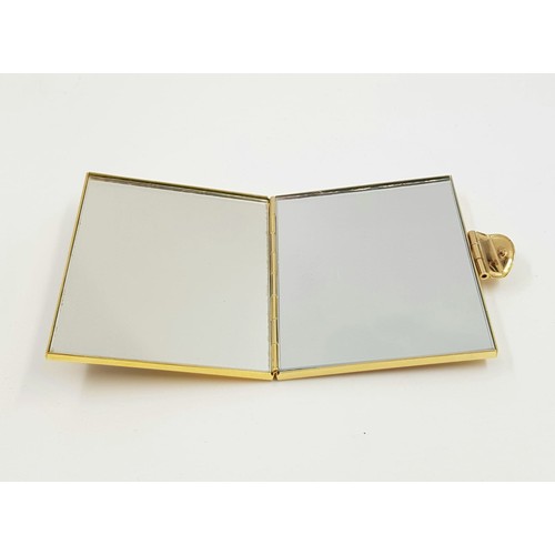 887 - A gold and silver effect metal vanity mirror case. As new with box. 7x6cm.