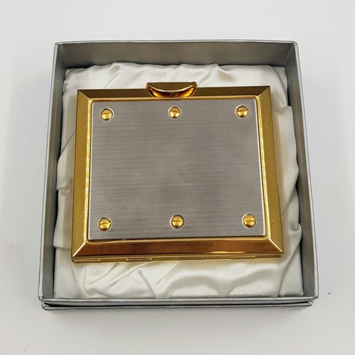 887 - A gold and silver effect metal vanity mirror case. As new with box. 7x6cm.