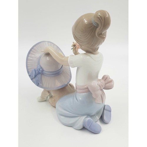 890 - A Lladro porcelain figurine of a girl patting a dog. 16cm high. Good condition.