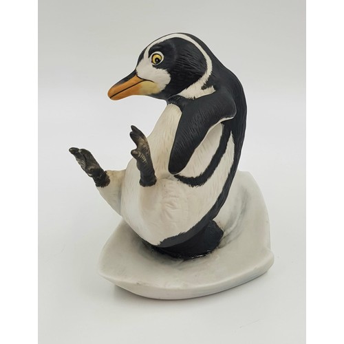 894 - A hand painted porcelain figurine of a penguin slipping on ice. 'Whoops!' Good condition. 15x15cm.