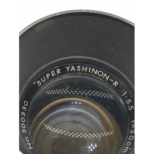 779 - A Yashica, No. 300330, super Yashinon-R lens. Good condition with case. 28cm long.