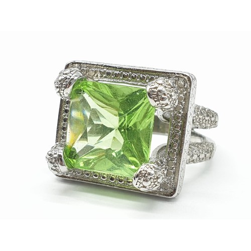 162 - A peridot sterling silver ring (stamped 925) and a matching earrings set presented in a vintage carv... 