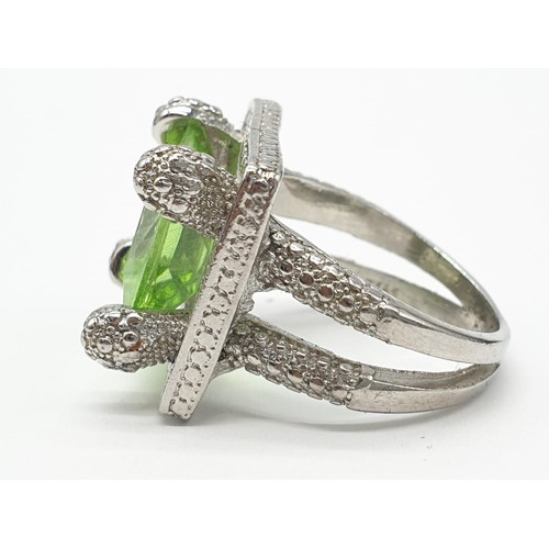 162 - A peridot sterling silver ring (stamped 925) and a matching earrings set presented in a vintage carv... 