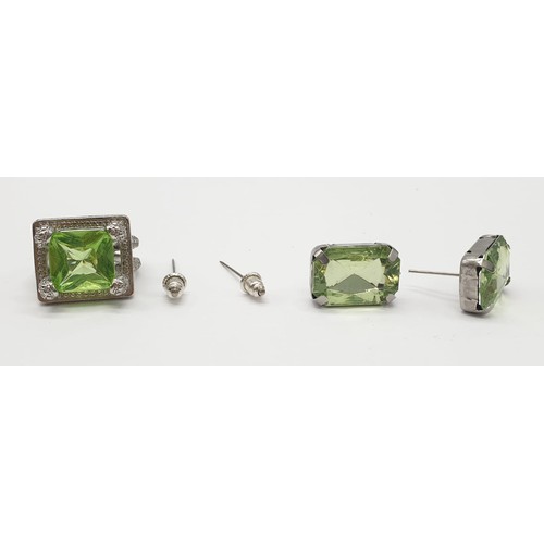 162 - A peridot sterling silver ring (stamped 925) and a matching earrings set presented in a vintage carv... 