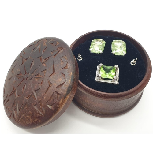 162 - A peridot sterling silver ring (stamped 925) and a matching earrings set presented in a vintage carv... 