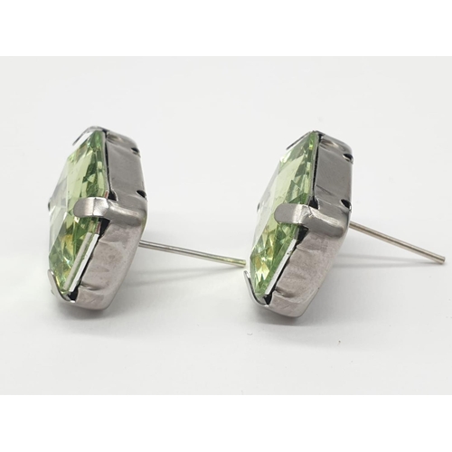 162 - A peridot sterling silver ring (stamped 925) and a matching earrings set presented in a vintage carv... 