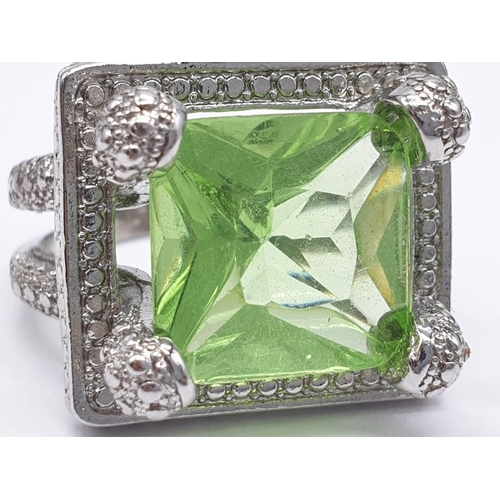 162 - A peridot sterling silver ring (stamped 925) and a matching earrings set presented in a vintage carv... 