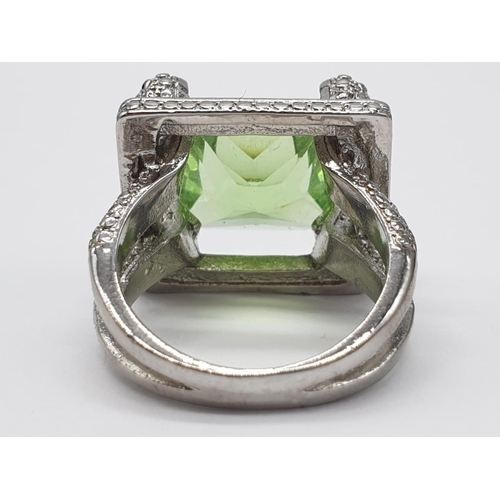 162 - A peridot sterling silver ring (stamped 925) and a matching earrings set presented in a vintage carv... 