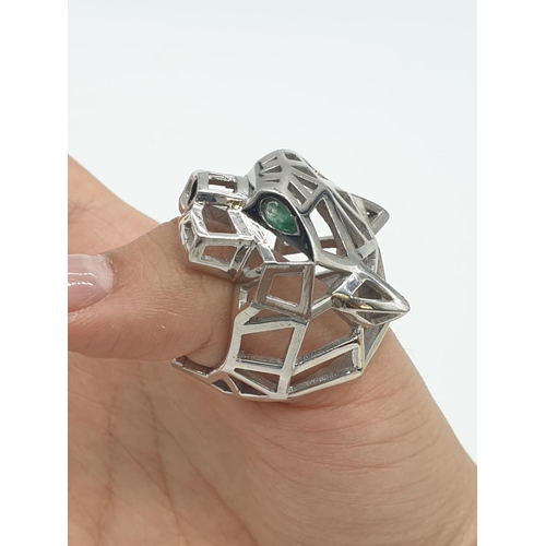 36 - A sterling silver Cartier Panther style lattice ring with emerald eyes. Ring Size: N, weight  19.5g.