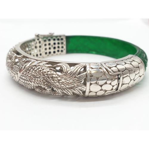 85 - A beautiful Chinese hand carved jade and sterling silver bracelet with engraved dragons. Internal di... 