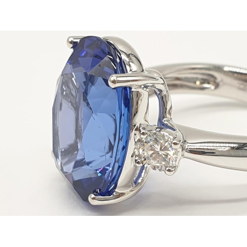 224 - 18ct White gold ring with a large tanzanite centre stone flanked by diamonds. 8.0g total weight and ... 