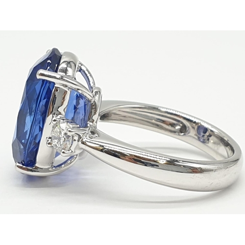 224 - 18ct White gold ring with a large tanzanite centre stone flanked by diamonds. 8.0g total weight and ... 