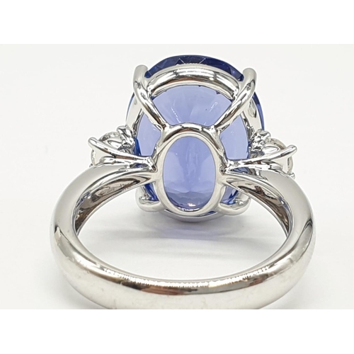 224 - 18ct White gold ring with a large tanzanite centre stone flanked by diamonds. 8.0g total weight and ... 