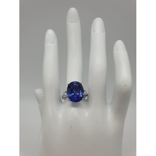 224 - 18ct White gold ring with a large tanzanite centre stone flanked by diamonds. 8.0g total weight and ... 