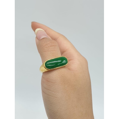 318 - 24ct gold ring with natural jade stone. Weighs 7.0g and is a size U.