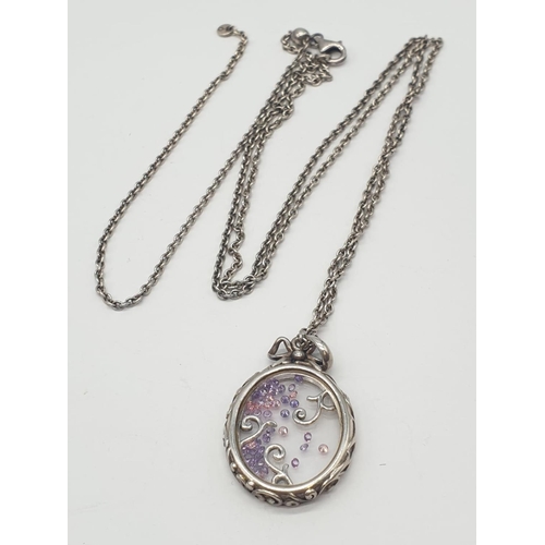 167 - Silver extendable chain and closed Glass locket with floating Amethysts, weight 14.5g