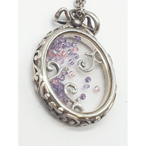 167 - Silver extendable chain and closed Glass locket with floating Amethysts, weight 14.5g