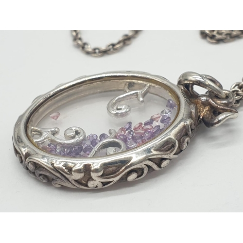 167 - Silver extendable chain and closed Glass locket with floating Amethysts, weight 14.5g