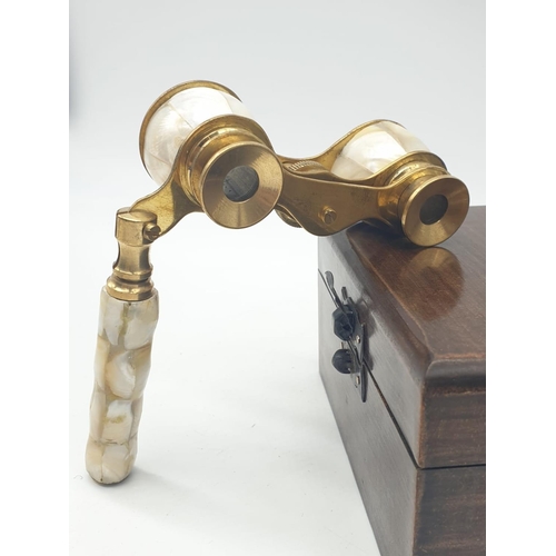 348 - 1920's Mother of Pearl & Brass opera glasses with folding handle, in wooden box. 13x7cm.