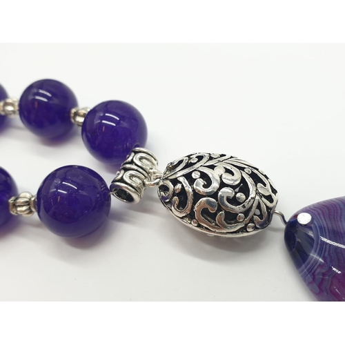 168 - A Tibetan silver with purple jade and agate necklace in a presentation box. Colour enhanced. Necklac... 