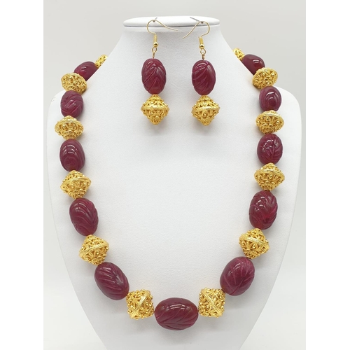 63 - An impressive Indian necklace and earrings set with engraved ruby cabochons and large pierced and gi... 