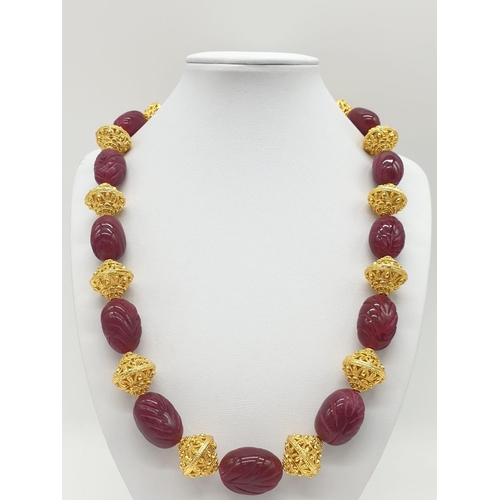 63 - An impressive Indian necklace and earrings set with engraved ruby cabochons and large pierced and gi... 