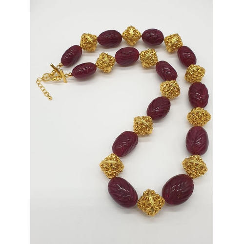 63 - An impressive Indian necklace and earrings set with engraved ruby cabochons and large pierced and gi... 