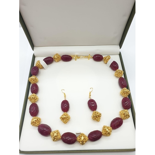 63 - An impressive Indian necklace and earrings set with engraved ruby cabochons and large pierced and gi... 