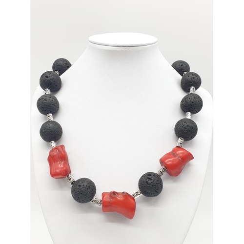 70 - A Hawaiian lava necklace and earrings set, adored with big chunks of Pacific red coral. In a present... 