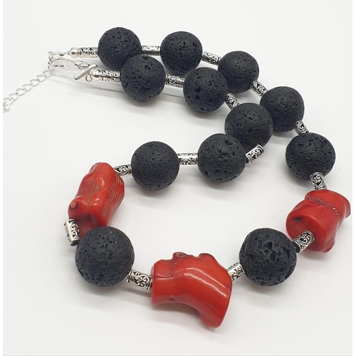 70 - A Hawaiian lava necklace and earrings set, adored with big chunks of Pacific red coral. In a present... 