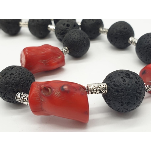 70 - A Hawaiian lava necklace and earrings set, adored with big chunks of Pacific red coral. In a present... 